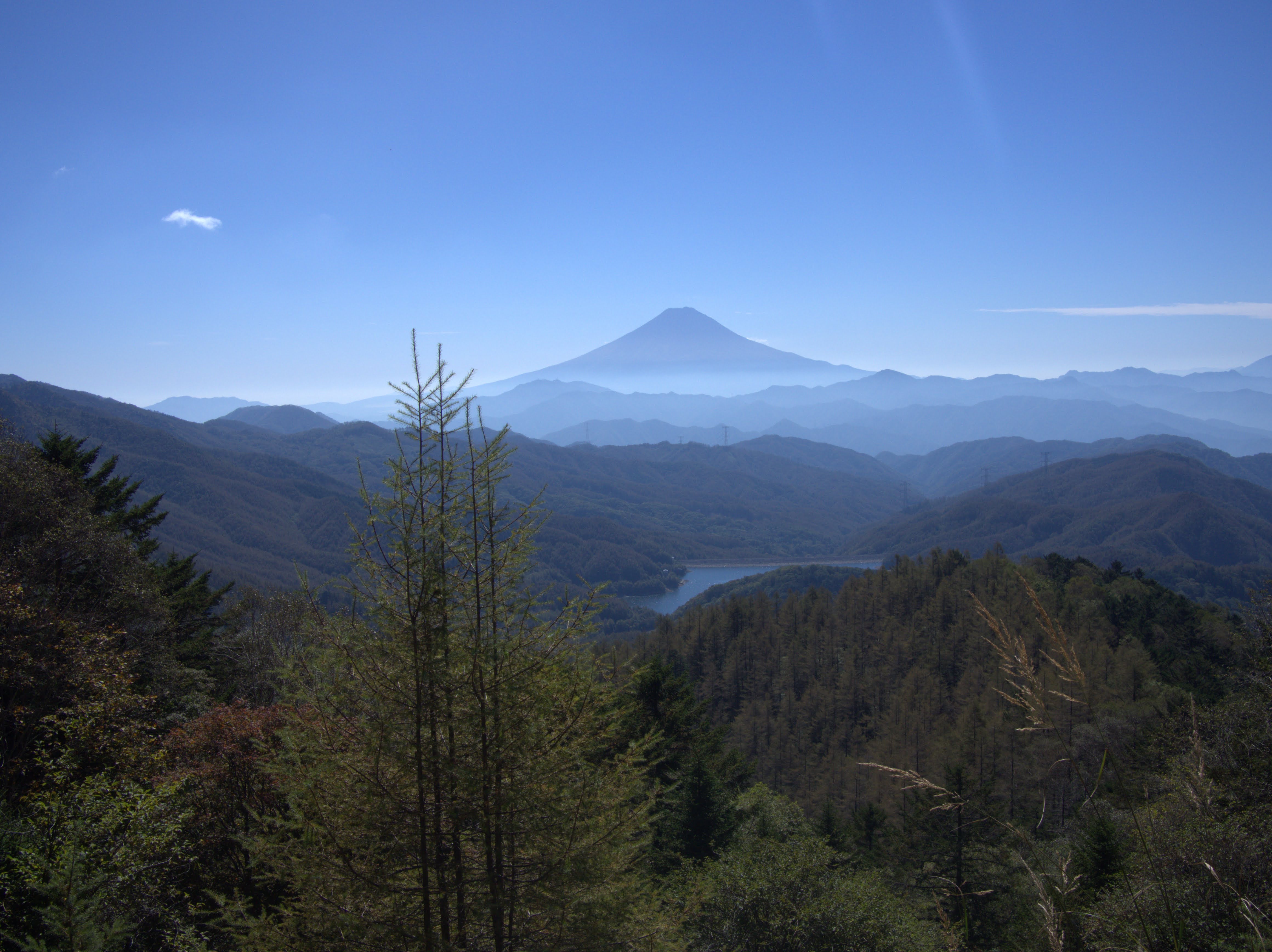 大菩薩湖の向こうに青い稜線と富士山が重なる景色（9歳の子どもが撮影）